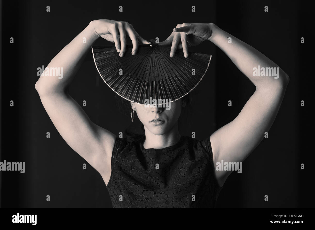 Hispanic Frau bedeckte ihr Gesicht mit faltbar Handfächer Stockfoto