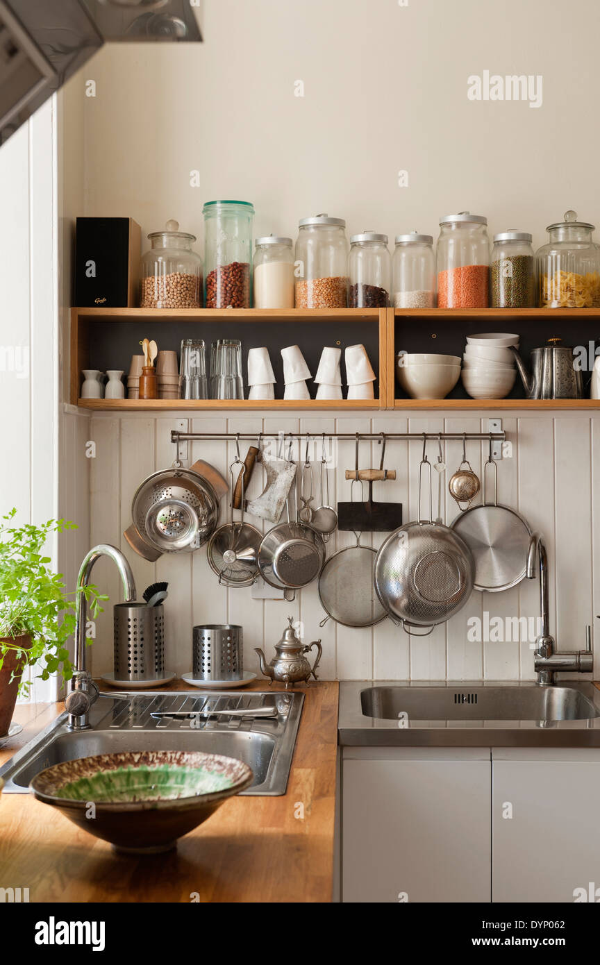 Getrocknete Zutaten auf offenen Regalen und Utensilien hängen von einem