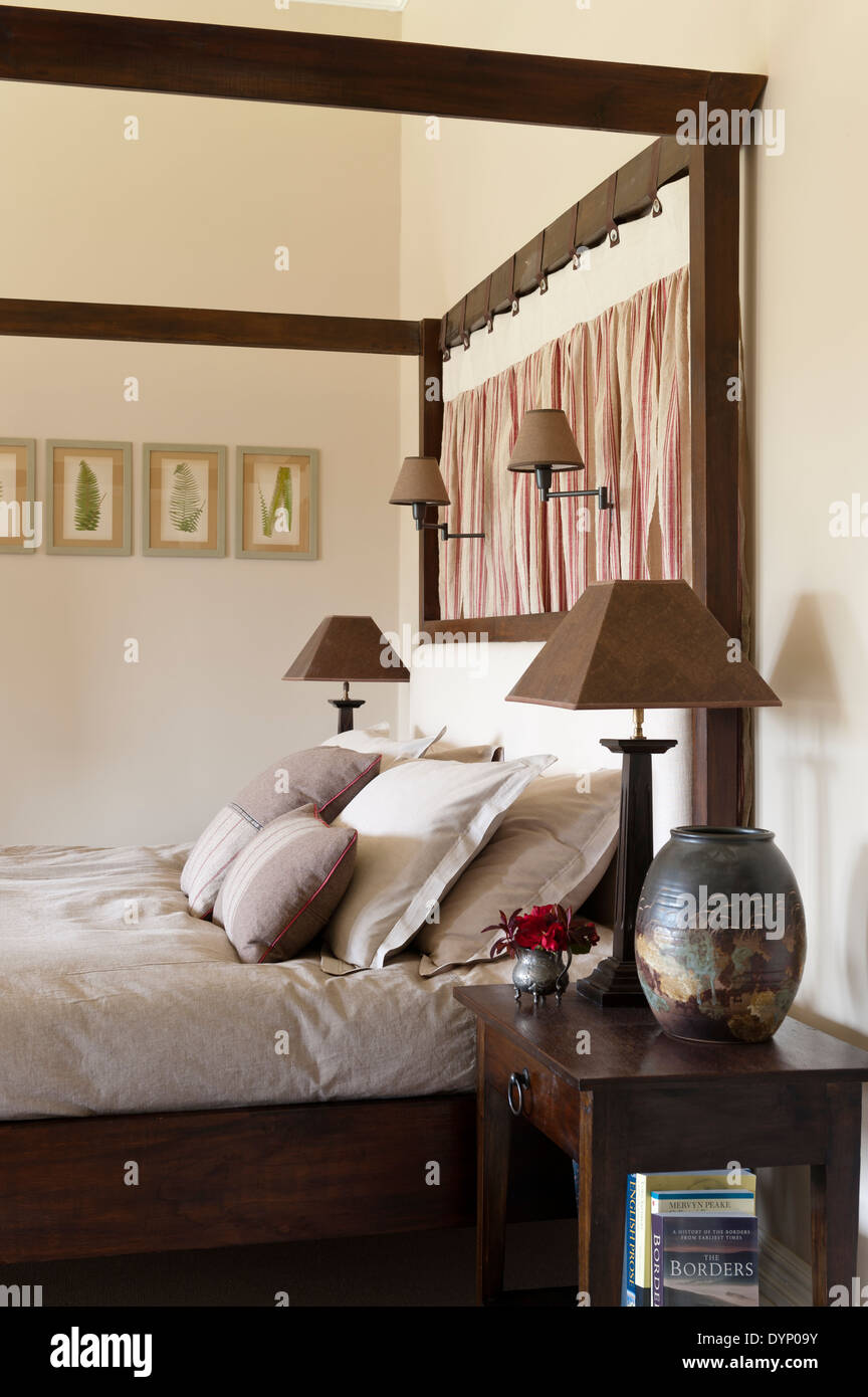 Vintage Leinen Kissenbezüge und ein Himmelbett Bett hängen flankiert von  Braun Lampen Stockfotografie - Alamy