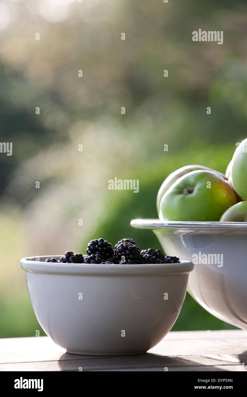 Brombeeren und Äpfel in Keramikschalen Stockfoto