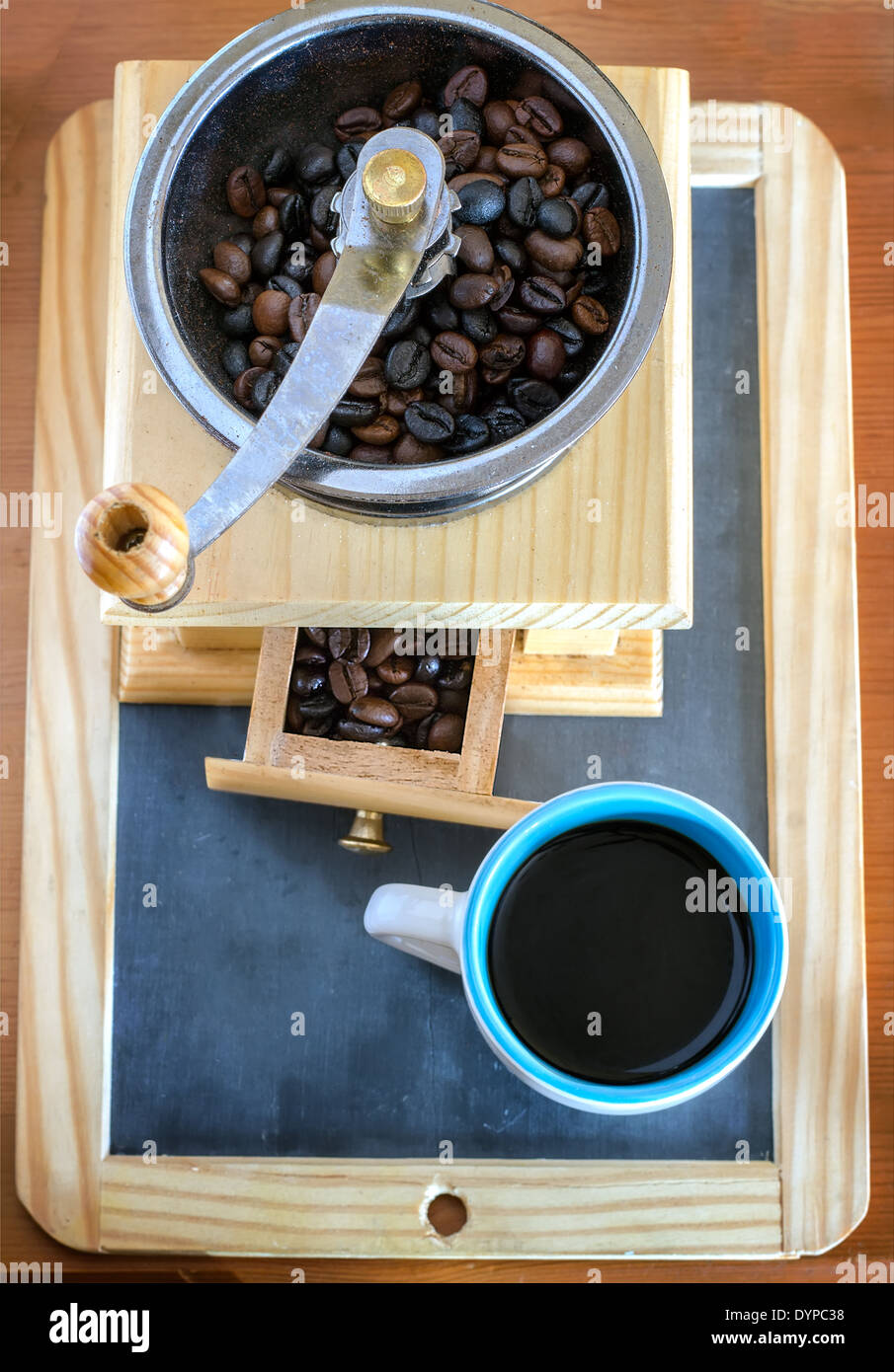 Tasse Kaffee, gebraut mit Bohnen und eine Kaffeemühle auf dem Blackboard-Hintergrund Stockfoto