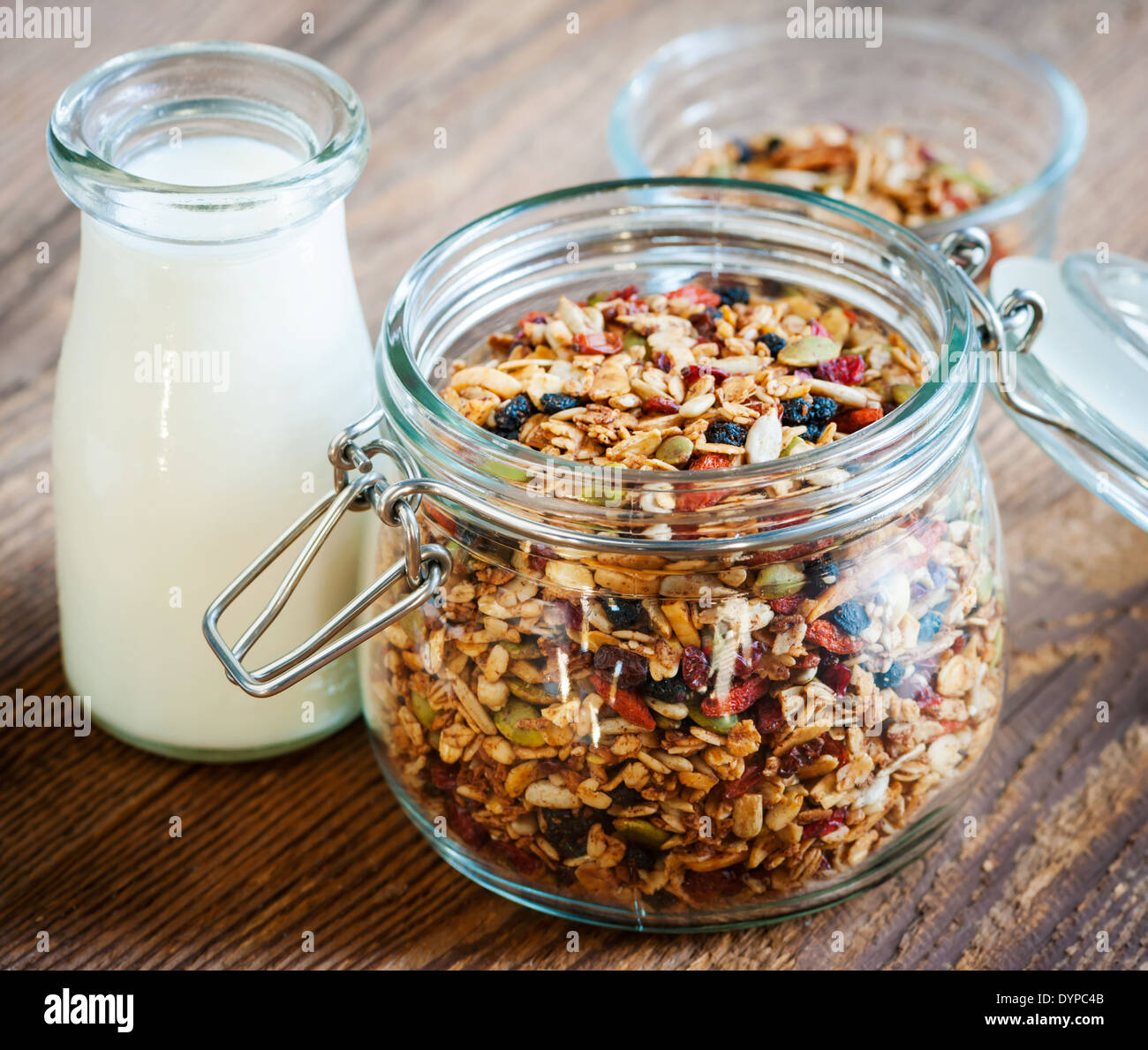 Offenen Draht Kaution Glas Müsli-Mischung mit Milch auf hölzernen Hintergrund Stockfoto