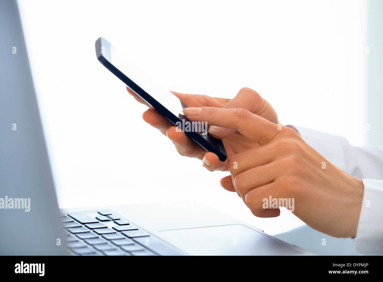 Geschäftsfrau, die Nachricht auf dem Handy im Büro zu schreiben. Stockfoto