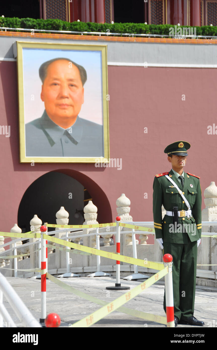 Eine chinesische Wache im Platz des himmlischen Friedens, Peking, stehen vor einem Porträt von Mao Zedong. Stockfoto