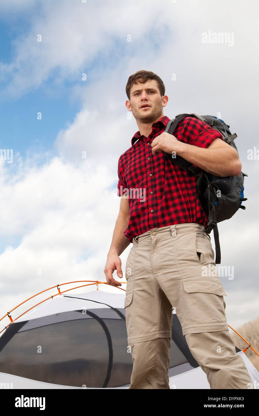 Wanderer richtet Camp mit Zelten und Feuerstelle Stockfoto