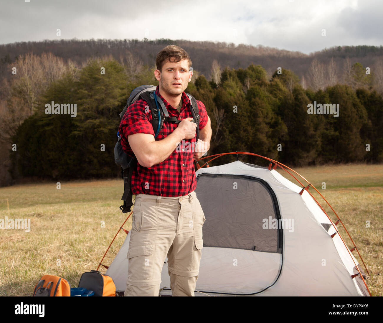 Wanderer richtet Camp mit Zelten und Feuerstelle Stockfoto