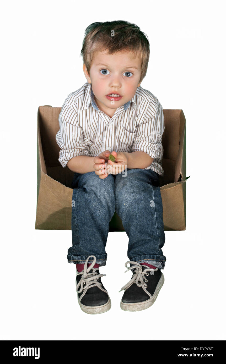 kleiner Junge sitzt in einer box Stockfoto