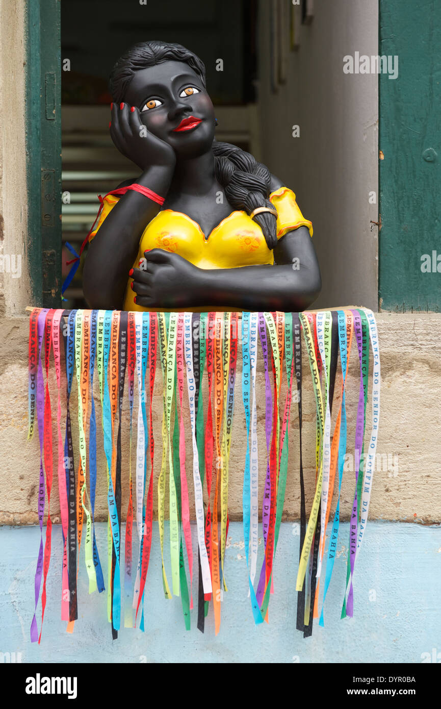 Lächelnd Brasilianerin bunte Namoradeira Figur im Fenster dekoriert mit Wunsch Bänder Fita Bonfim Salvador Bahia Stockfoto