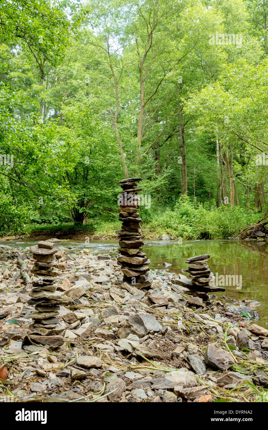 drei Steinen Pyramide in der Nähe von kleinen Fluss symbolisiert Zen, Harmonie, Gleichgewicht Stockfoto