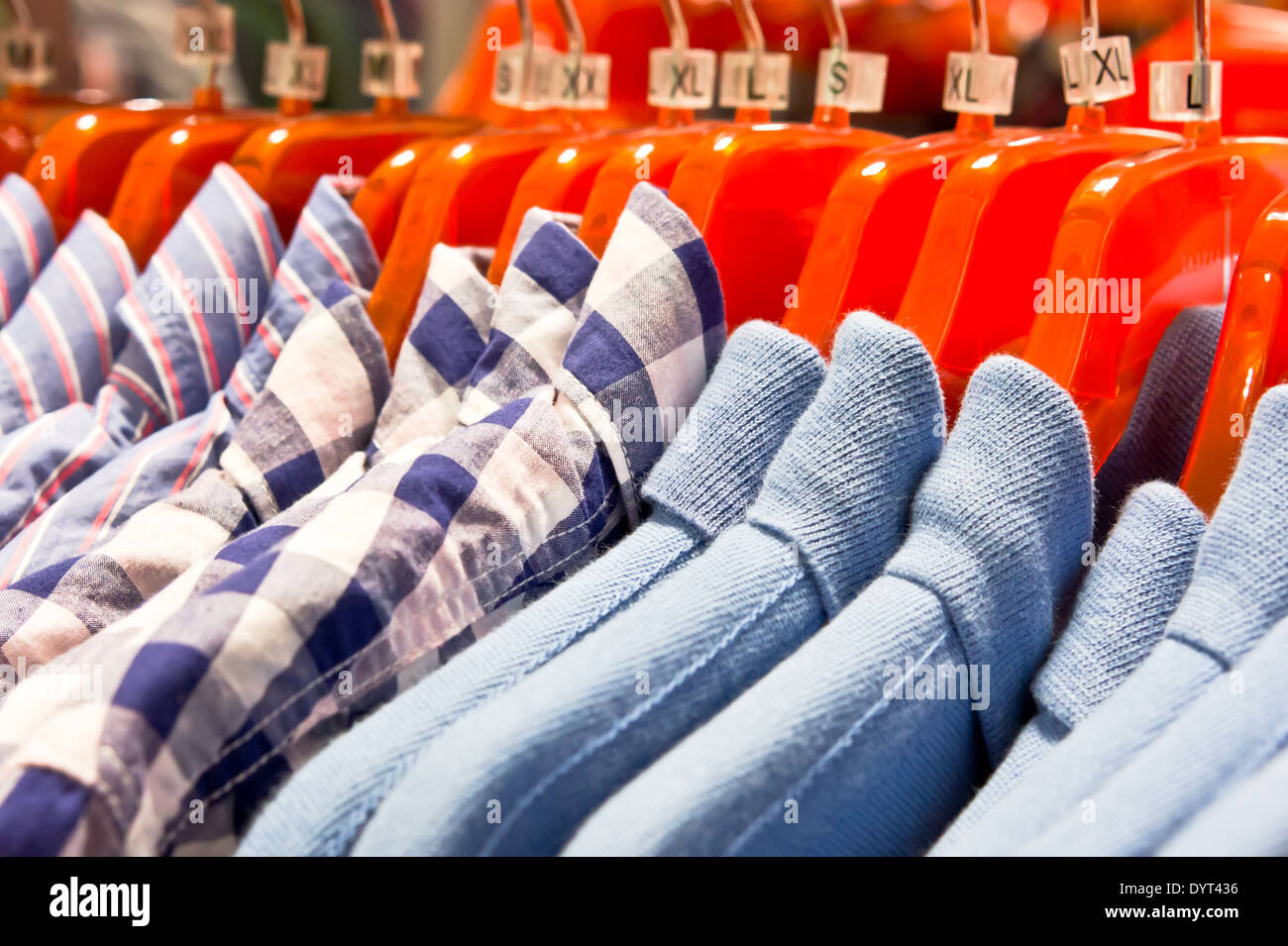 Stilvolle Herrenhemden orange Kleiderbügel hängen Stockfoto