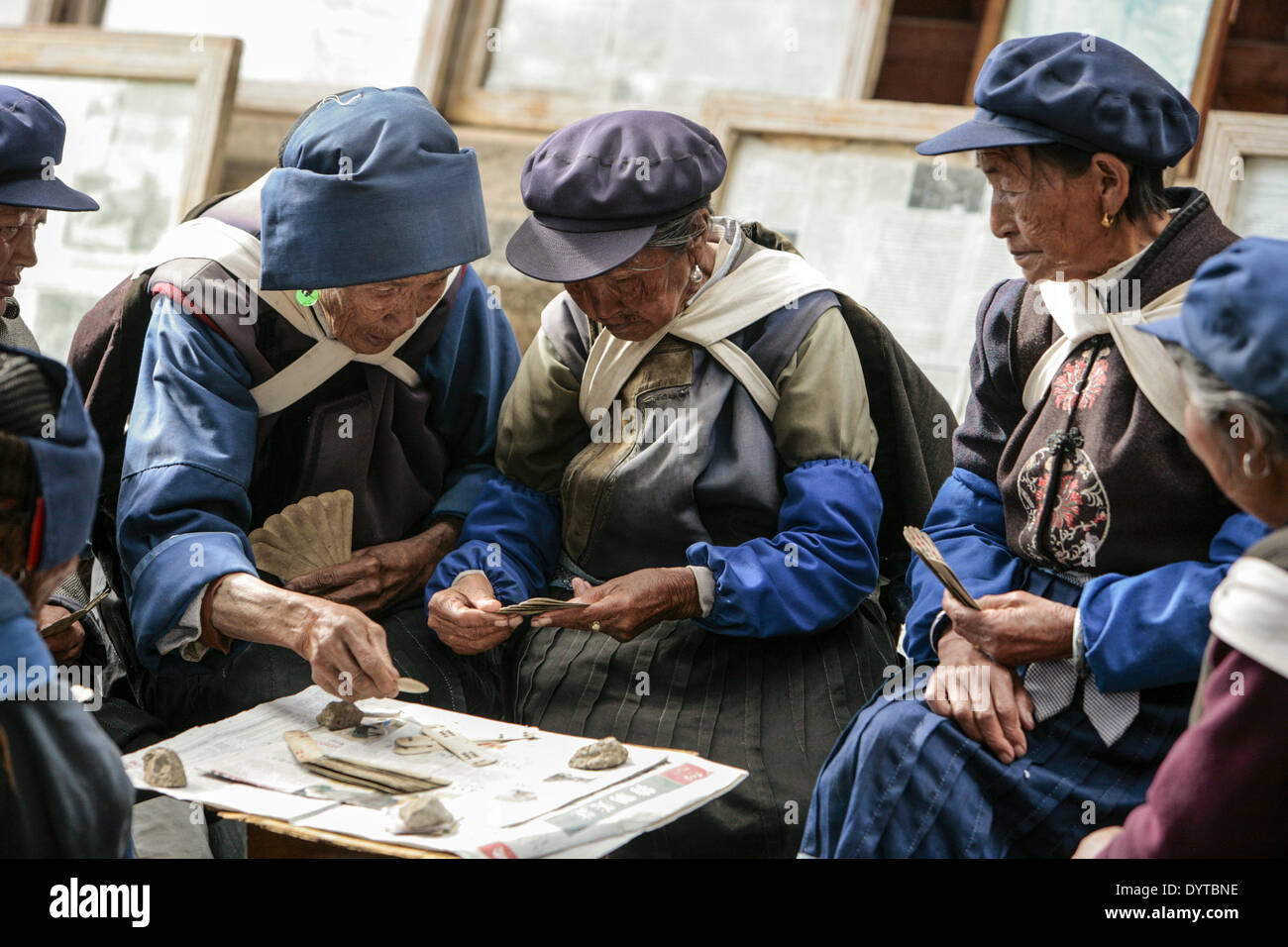 Drei Frauen in Führungspositionen des Ethncity Naxi spielen Karten in Shu He antike Stadt in der Provinz Yunnan Stockfoto