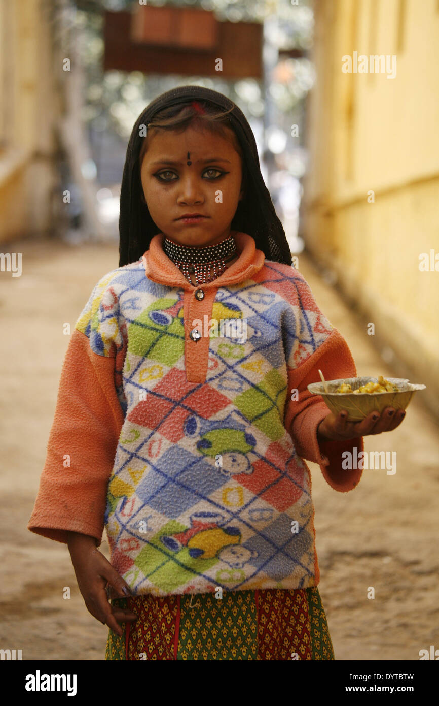 Ein kleines Mädchen hält einige Snacks in einer Gasse in Pushkar Stadt Fuß Stockfoto