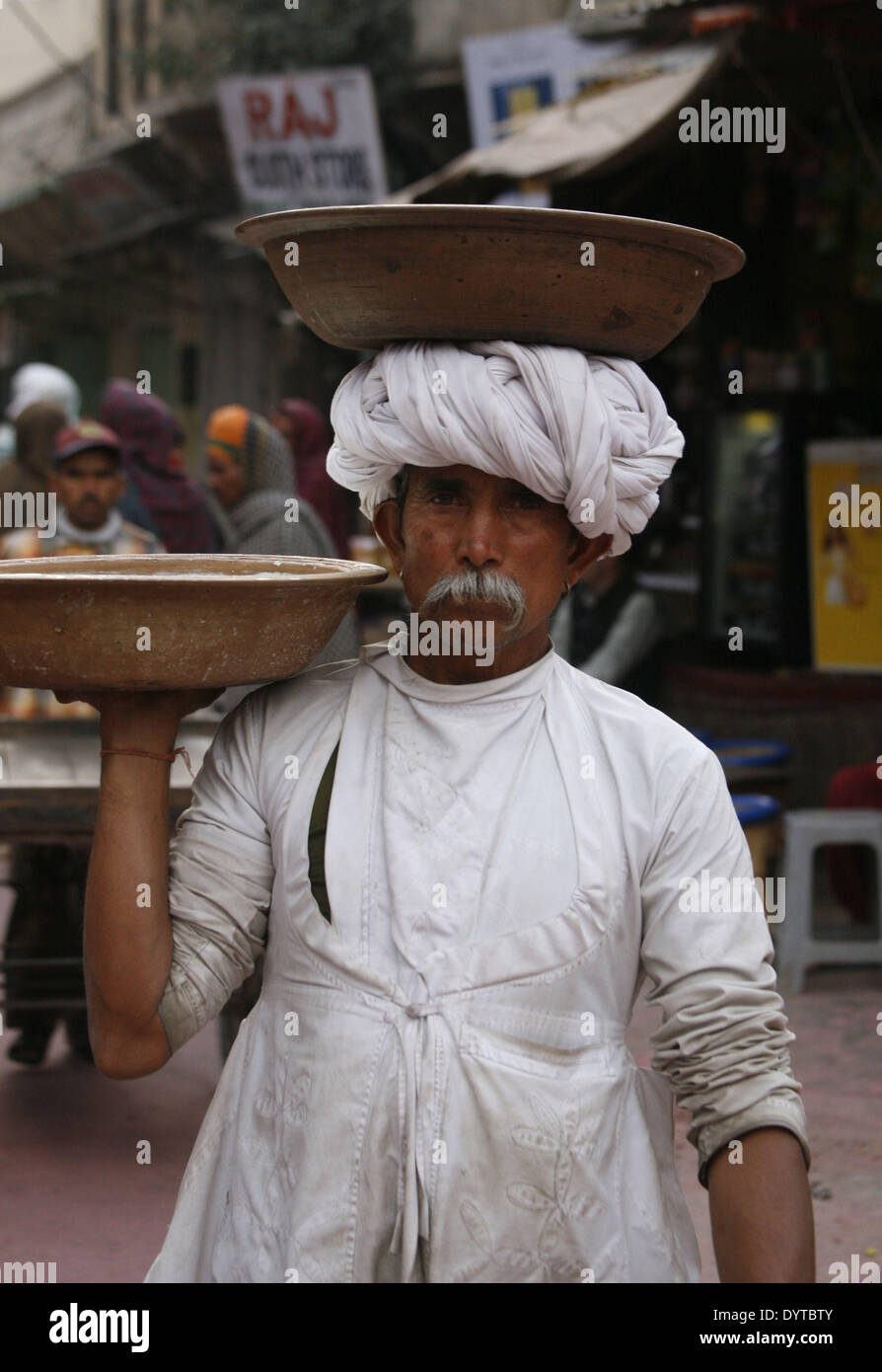 Eine Mann tragen Milch im Container auf seinem Kopf geht auf einem Markt in Pushkar Stadt Stockfoto