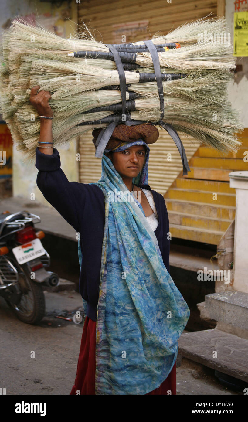 Eine Frau trägt auf dem Kopf Besen zu verkaufen Stockfoto
