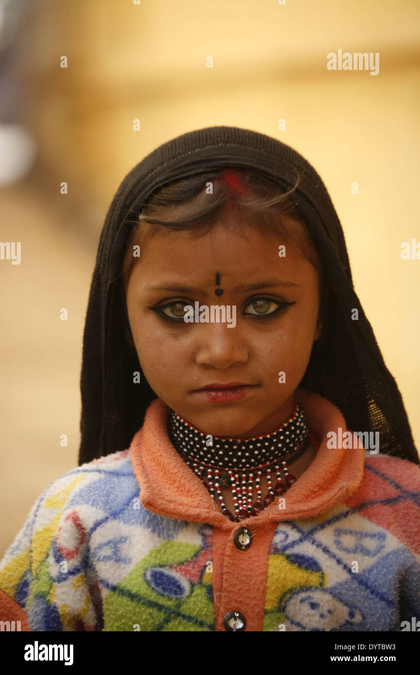 Ein kleines Mädchen hält einige Snacks in einer Gasse in Pushkar Stadt Fuß Stockfoto