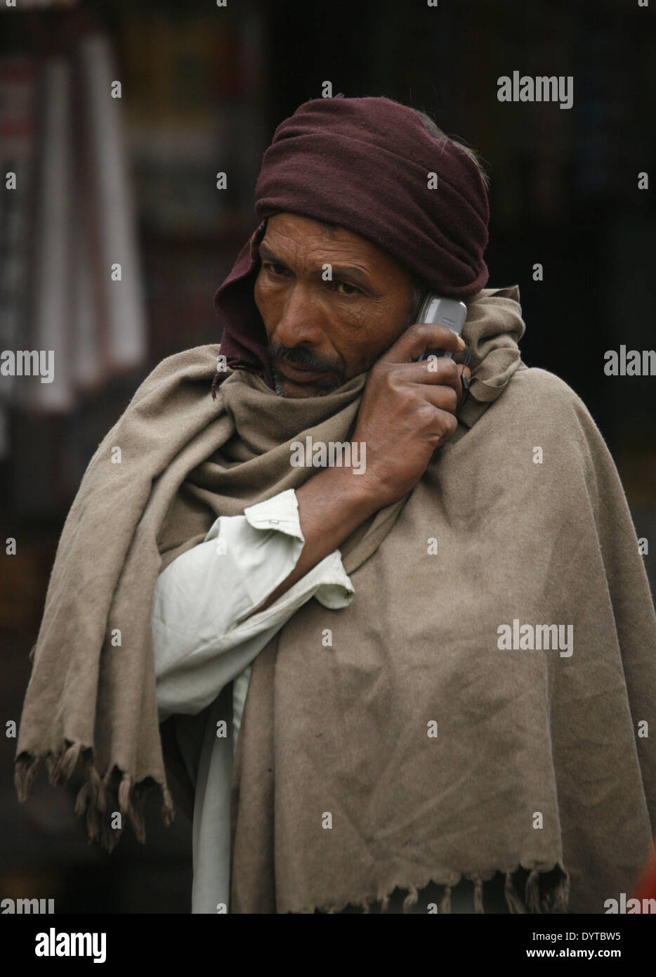 Ein Mann nutzt sein Handy auf einer Straße in Pushkar Stadt Stockfoto