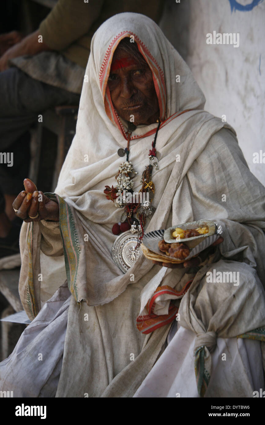 Eine Frau isst ihr Snack am Straßenrand in Pushkar Stadt Stockfoto