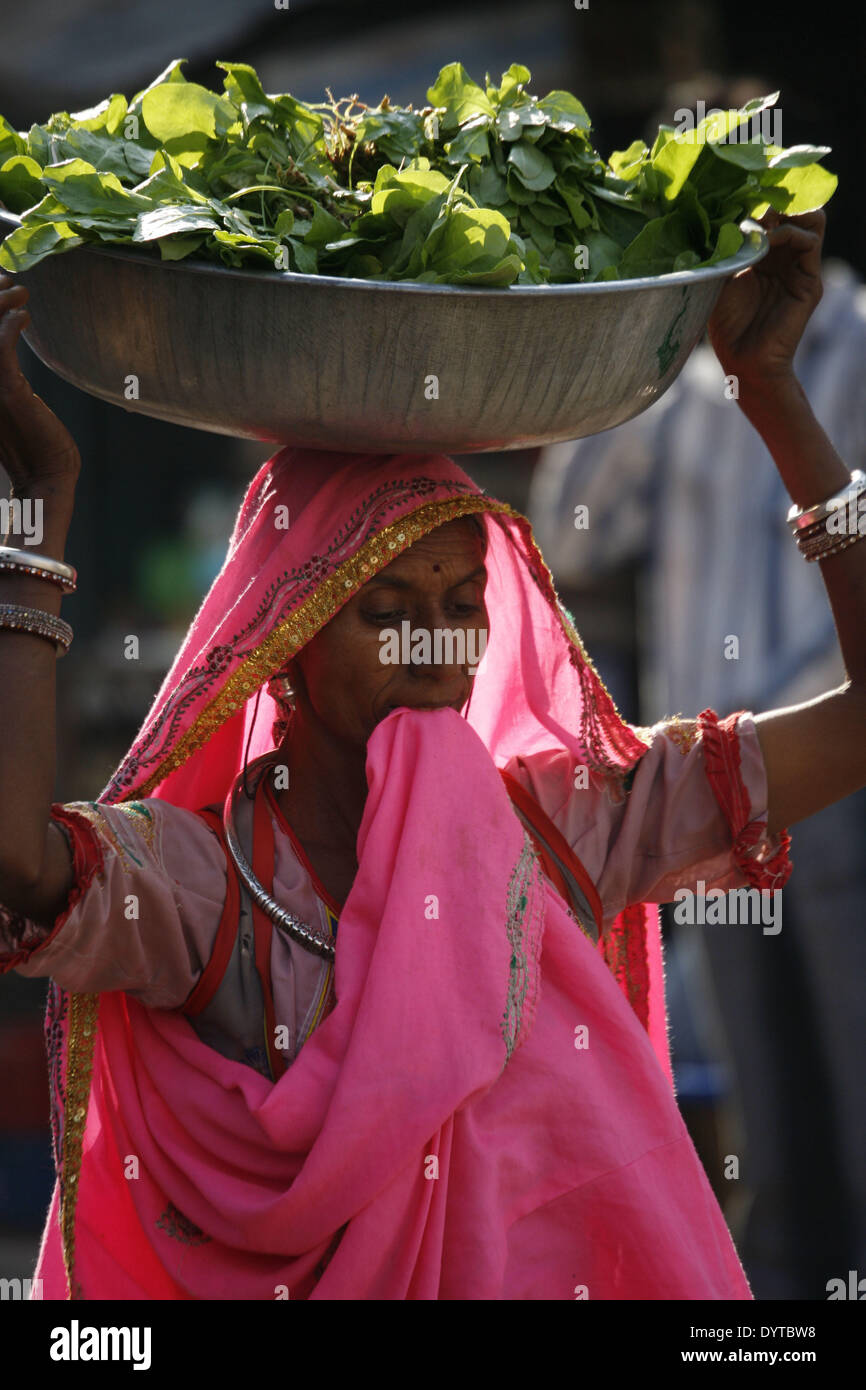 Eine Frau trägt auf dem Kopf eine Pflanze Stockfoto