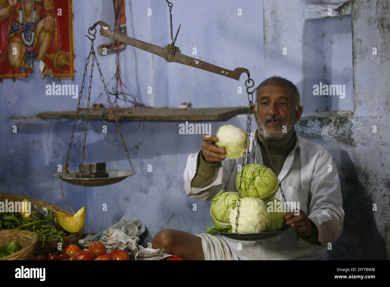 Ein Gemüsehändler Gewichte Kohl für einen Kunden in einem Shop in Pushkar Stadt Stockfoto