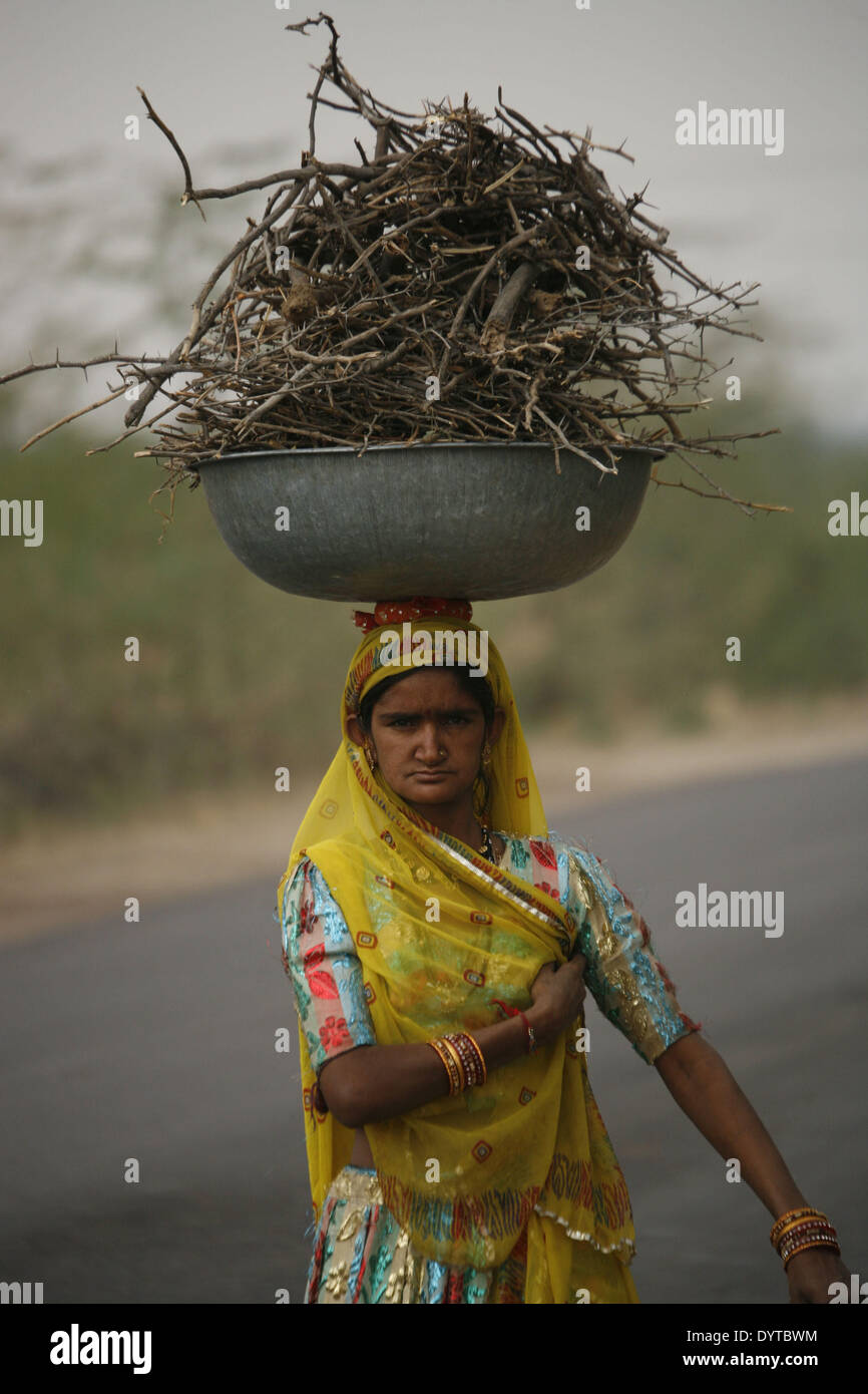 Eine Frau bringen einige trockenes Holz auf dem Kopf Stockfoto