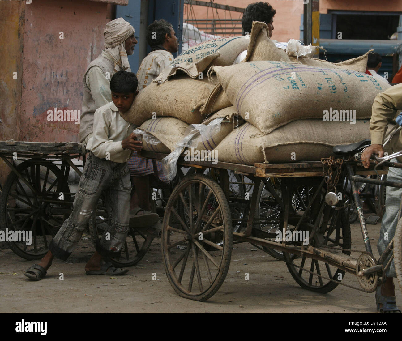 Ein Kind-Push ein Dreirad mit waren auf einer Straße von Agra beladen Stockfoto