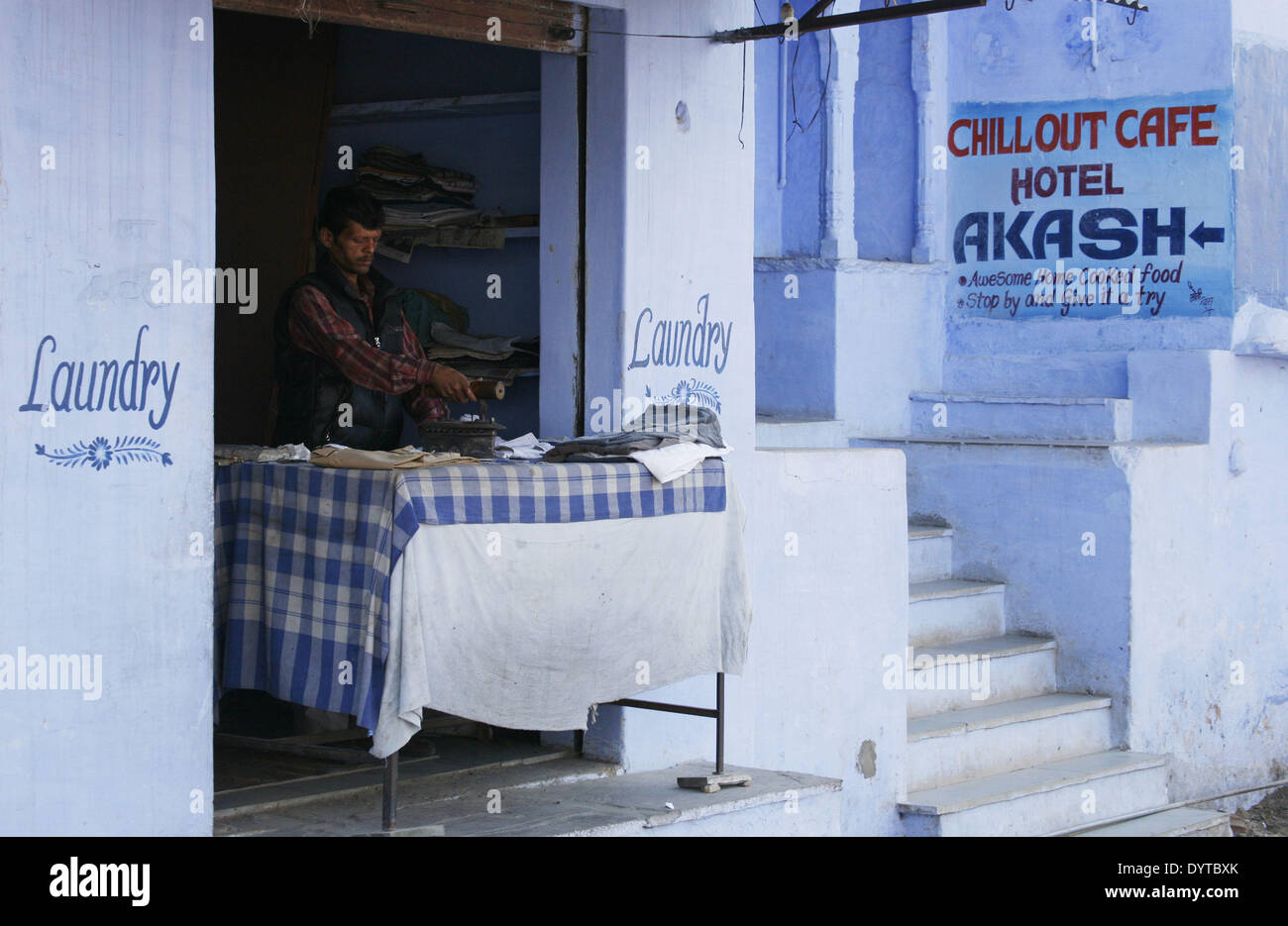 Ein Mann Bügeln einige Kleider an eine Wäscherei in Pushkar Stadt Stockfoto
