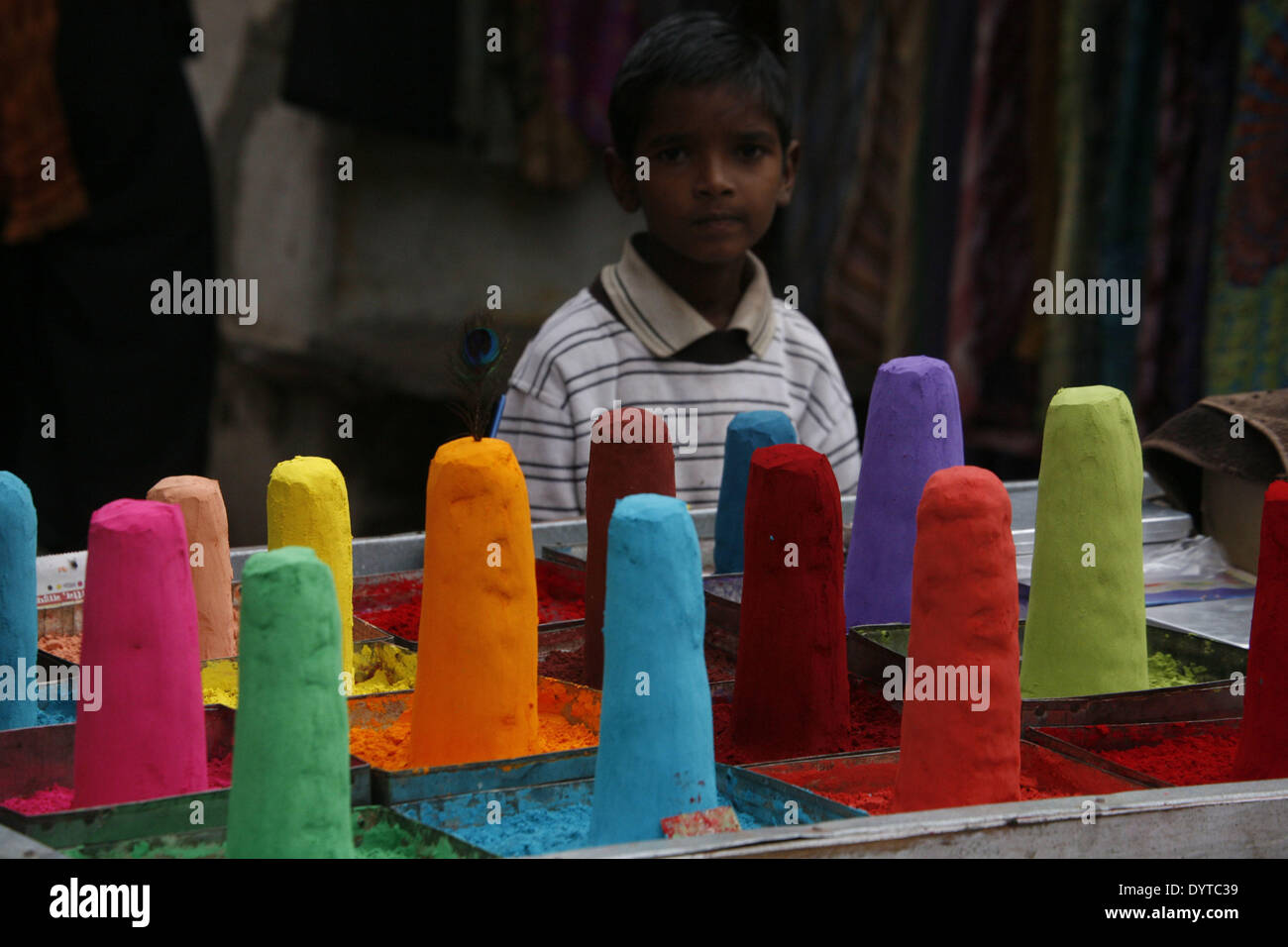 Ein Junge hinter einem Stall zu verkaufen Farbstoff für Festivals auf einem Markt in Pushkar Stadt Stockfoto