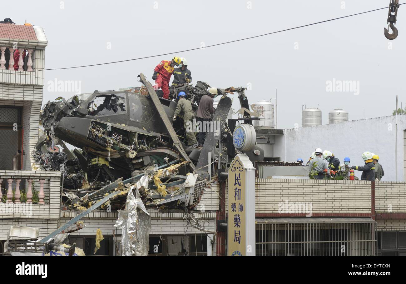 Taoyuan, Taiwan. 25. April 2014. Feuerwehrleute reinigen die Unfallstelle von einem Militärhubschrauber Absturz in einem Wohnhaus im Südosten Taiwan Taoyuan County 25. April 2014. Der Absturz verletzt zwei Piloten an Bord, sagte Feuerwehrleute. Keine Explosion oder Feuer aufgetreten. Die beiden verletzten Piloten haben zum Krankenhaus gehetzt worden und sind in einem stabilen Zustand. Bildnachweis: Huang Xiaoyong/Xinhua/Alamy Live-Nachrichten Stockfoto