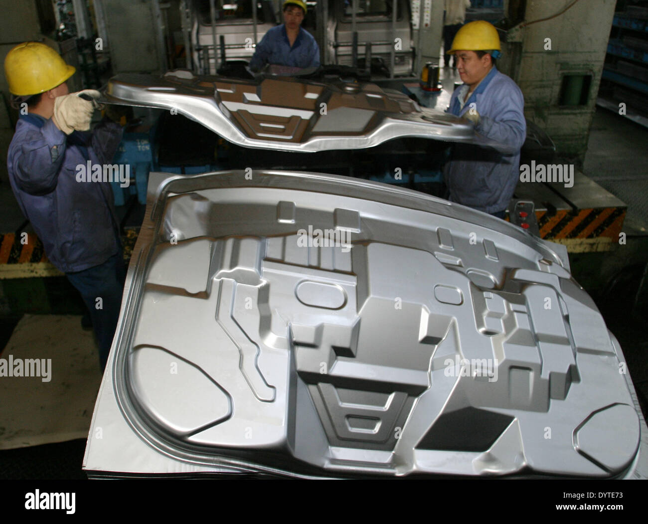 Chinesische Arbeiter Stempeln Sie das Körperteil an einen Minivan-Produktionslinie von Hafei Automobile Manufacturing Stockfoto