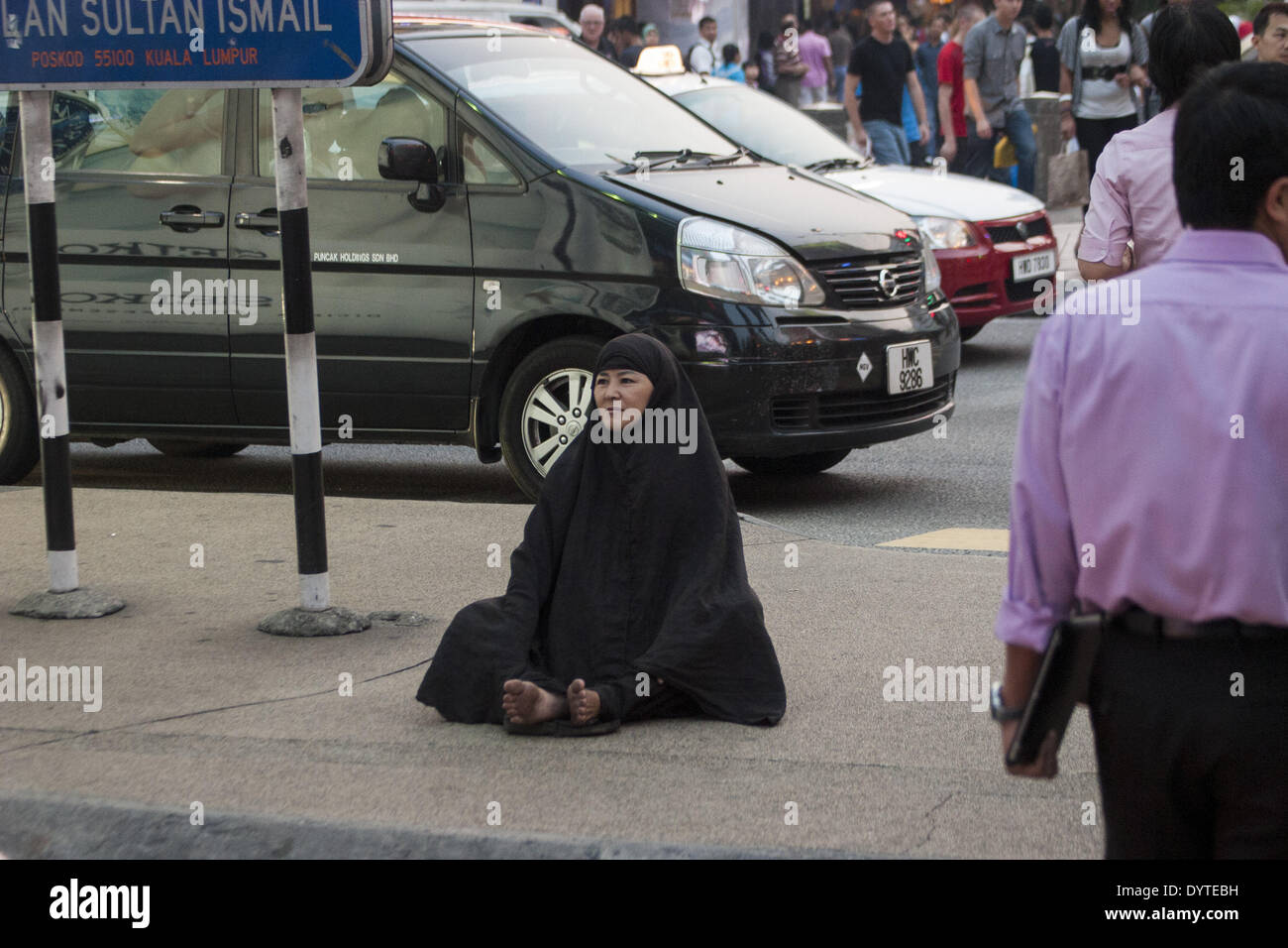 Eine Frau sitzen auf einer Steet in der Innenstadt von Kuala Lumpur Stockfoto