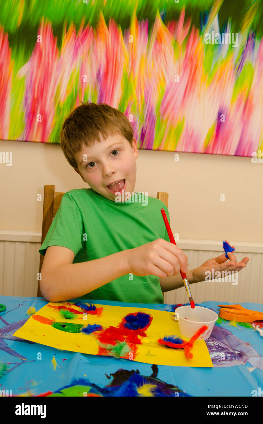 acht Jahre alter Junge Kunst und Handwerk Montage mit Klebstoff Schere und Farbe zu tun. Stockfoto