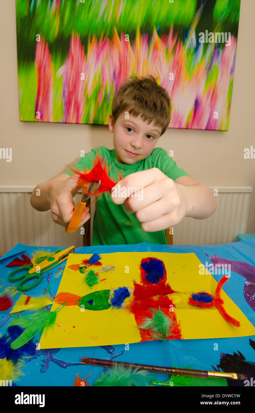 acht Jahre alter Junge Kunst und Handwerk Montage mit Klebstoff Schere und Farbe zu tun. Stockfoto