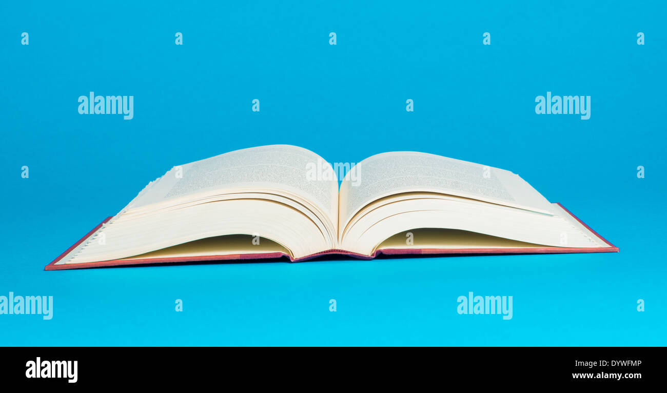Ein offenes Buch auf einem leuchtend blauen Hintergrund Stockfoto