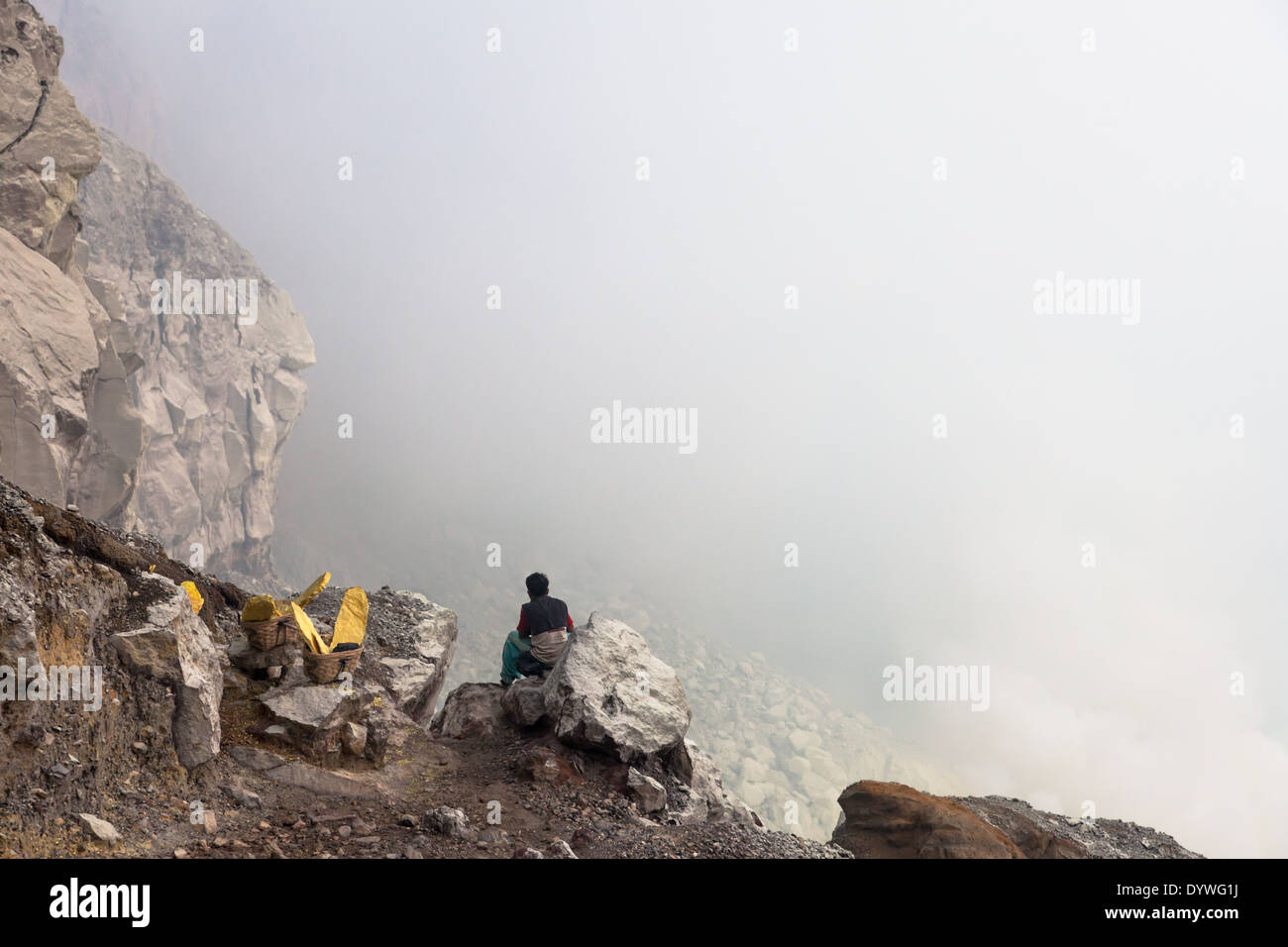 Sitzen Mann und Körben beladen mit Blöcken von Schwefel, Kawah Ijen, Banyuwangi Regency, Ost-Java, Indonesien Stockfoto