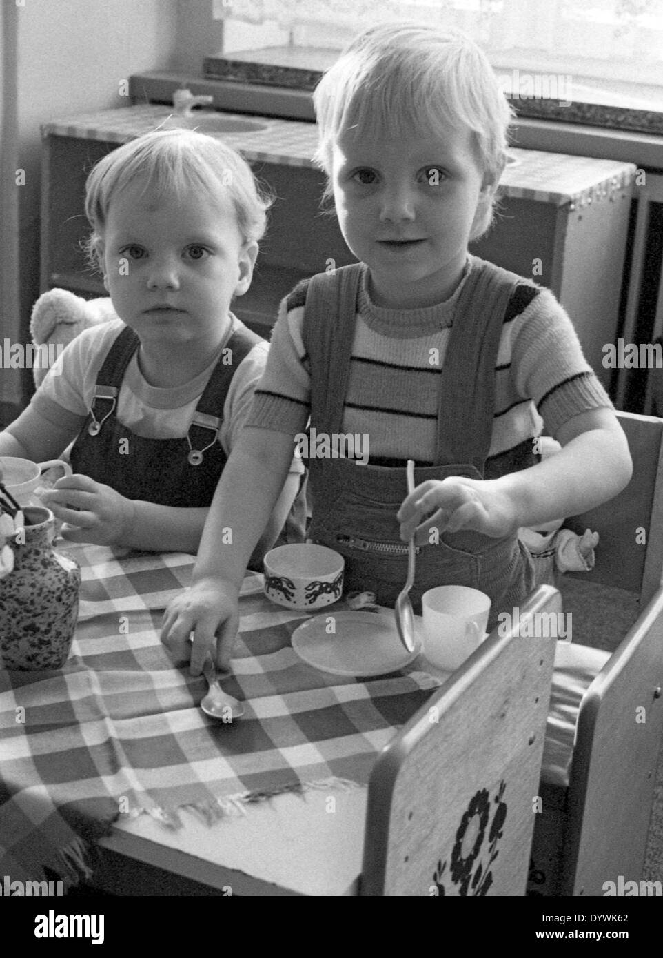 Berlin, DDR, Kleinkind im Kindergarten sitzen an einem Tisch essen Stockfoto