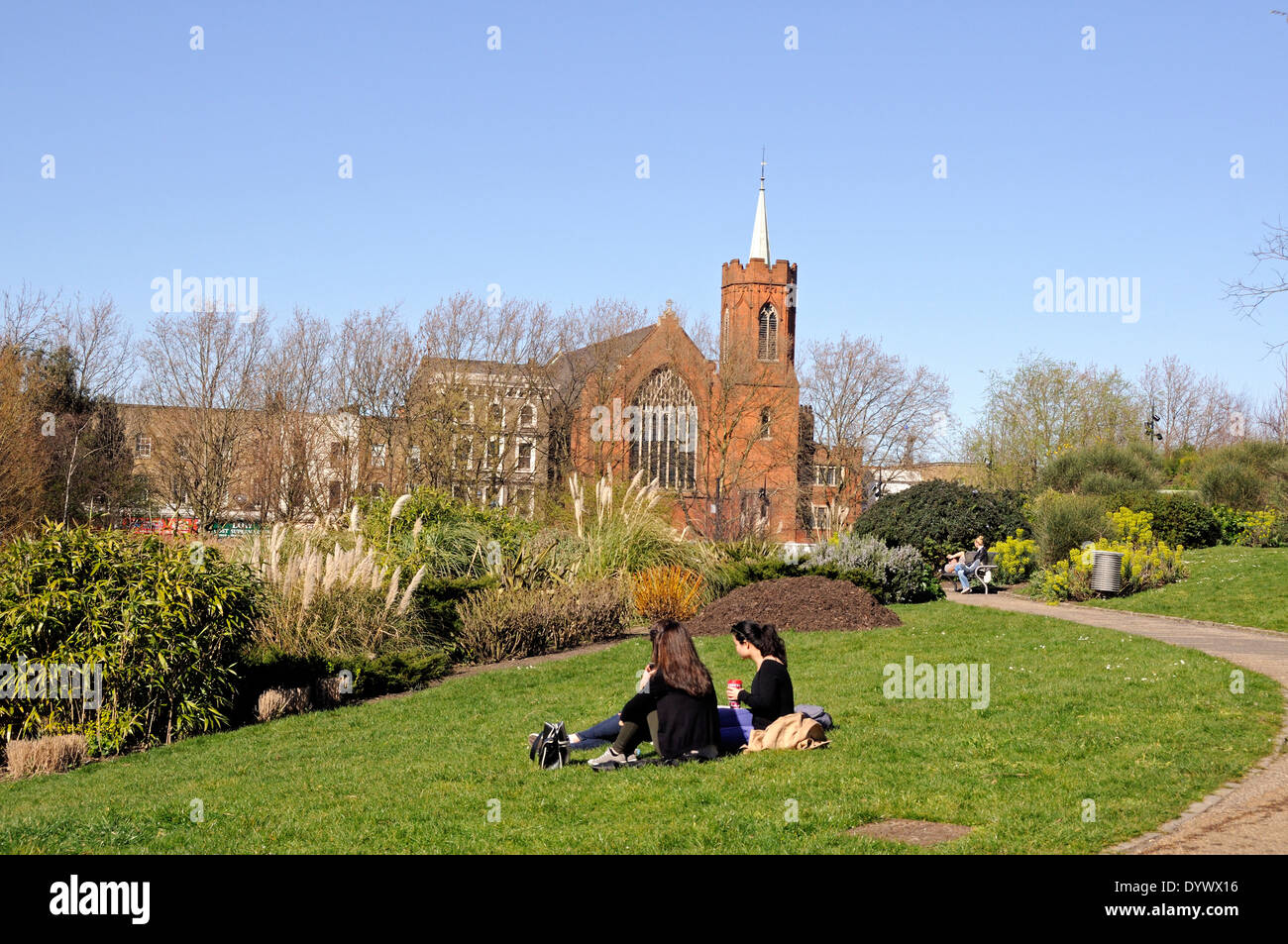 Mile End Park mit Leute sitzen auf den Rasen und die Schutzengel-Kirche in ferne London Borough of Tower Hamlets UK Stockfoto