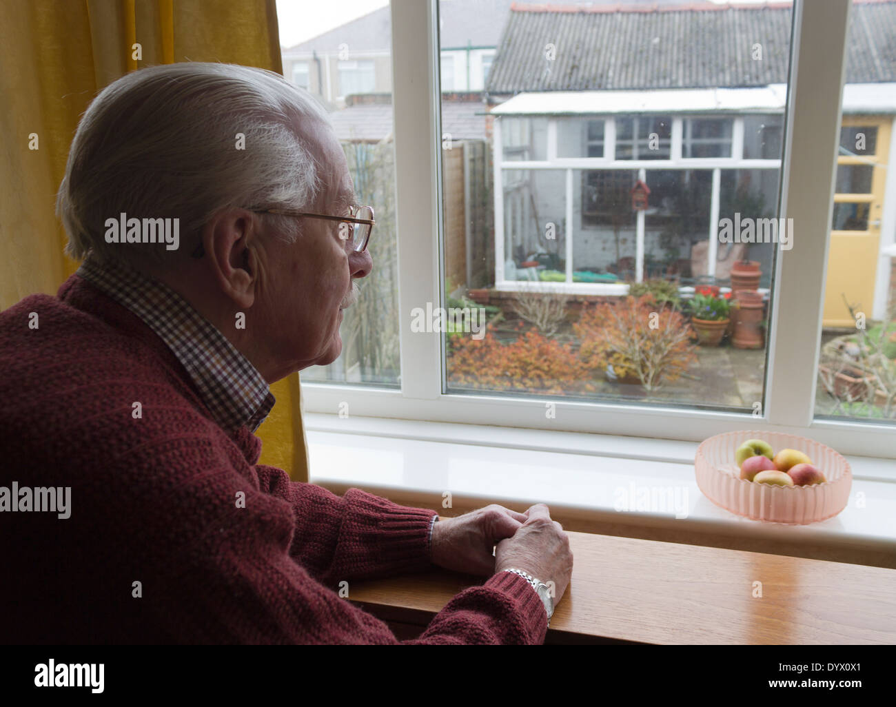 Einsamer alter Mann aus Fenster im Garten. Stockfoto