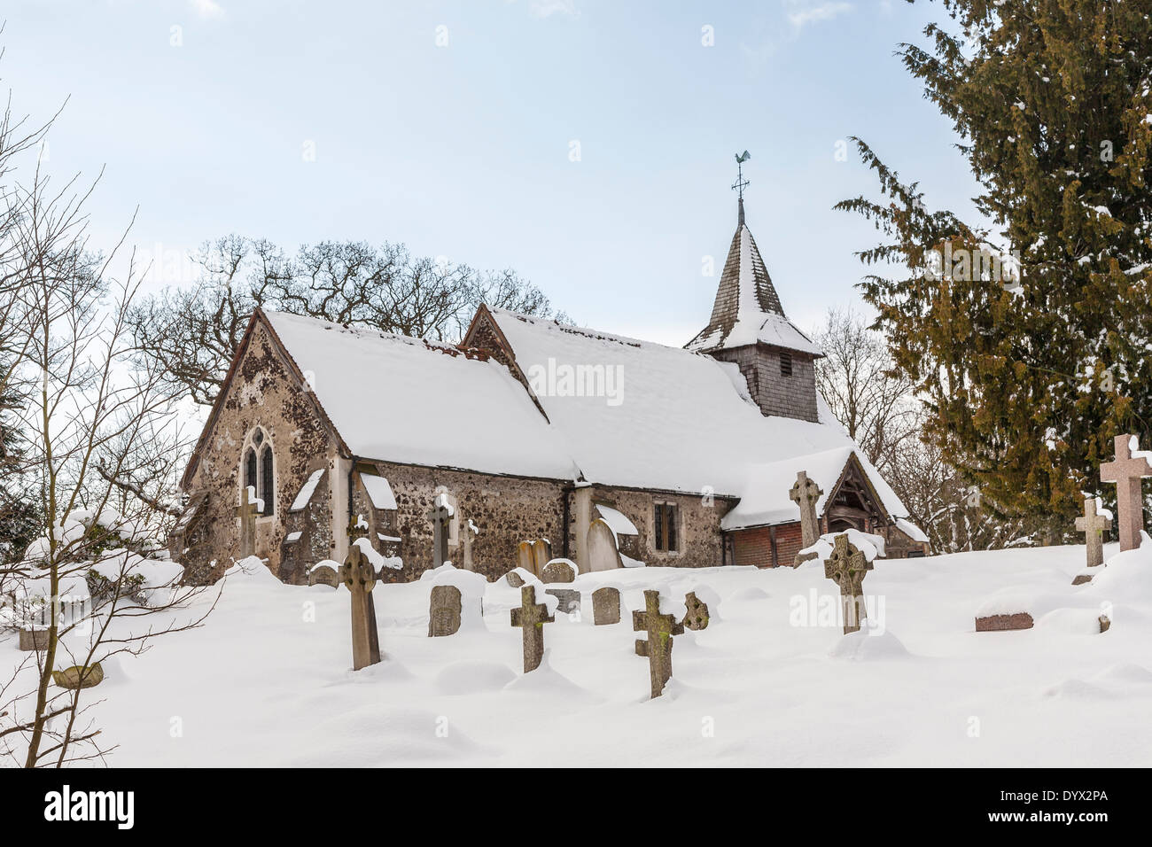 Kirche und Kirchhof von St. Nikolaus, Pyrford, Surrey, UK im Schnee im winter Stockfoto