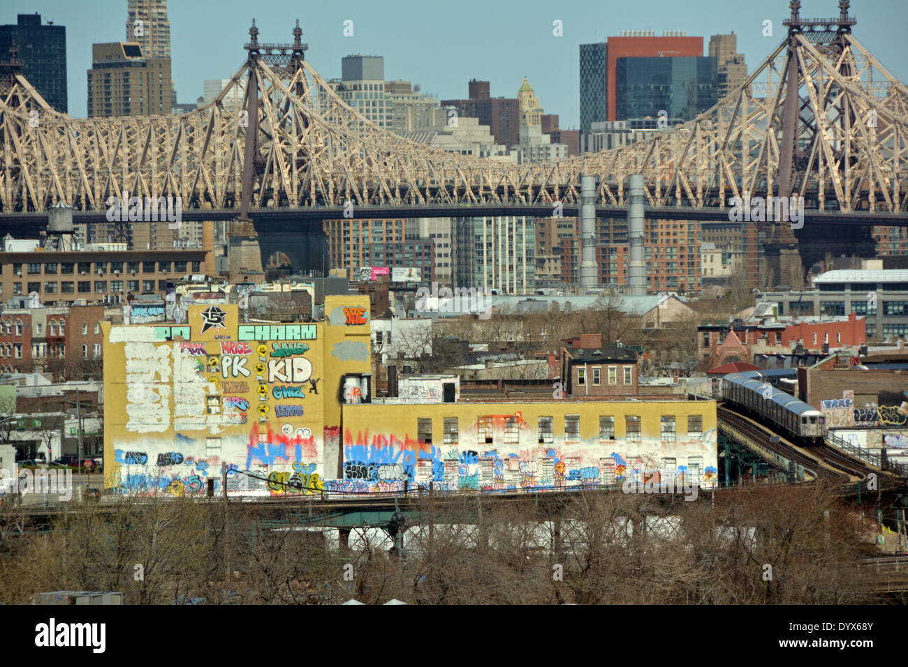 5 Pointz Graffiti-Museum mit der 59th Street Bridge und Manhattan Skyline im Hintergrund und der u-Bahn im Vordergrund. Stockfoto