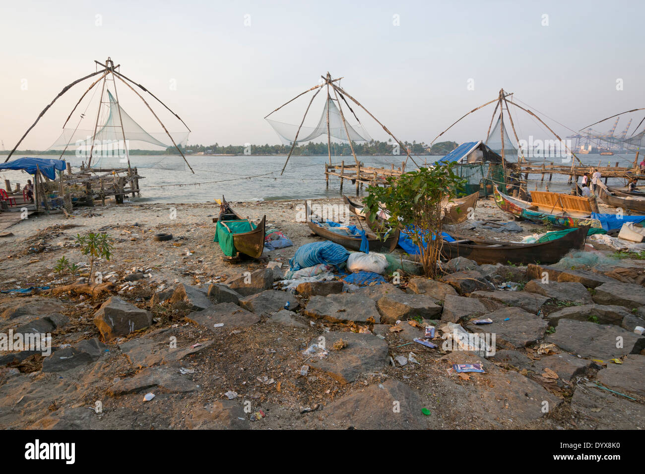 Rubish und Müll verstreut unter den Angelboote/Fischerboote und die chinesischen Fischernetze auf die Küste von Fort Kochi, Kerala, Indien Stockfoto