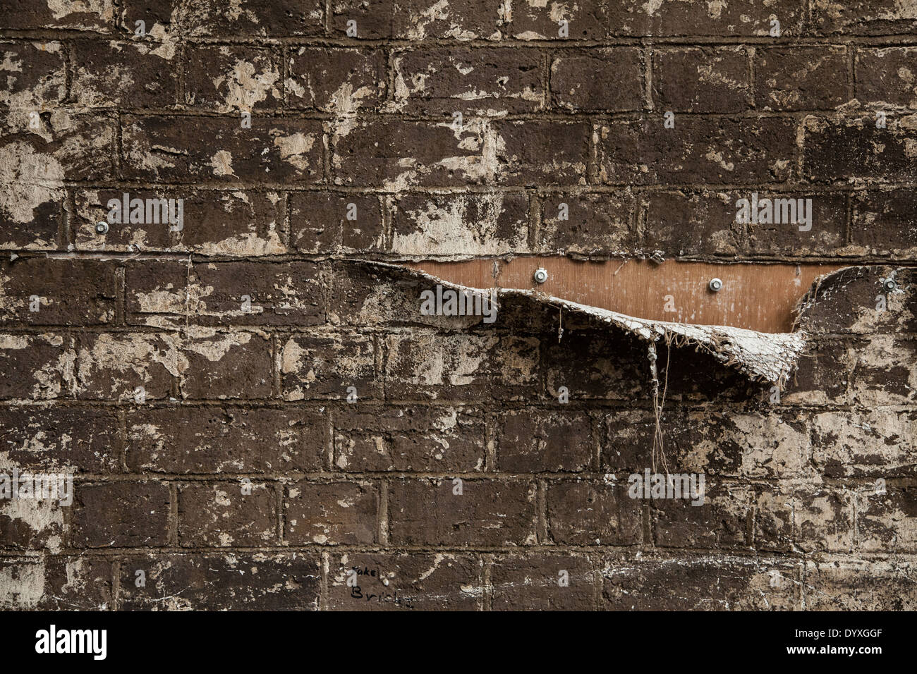 Eine Träne in einem Stoff verwendet, um eine gefälschte Mauer auf ein Theater zu machen legen enthüllt die hölzernen Hintergrund Stockfoto