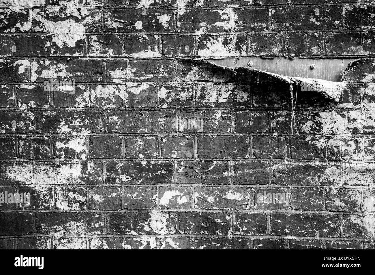 Eine Träne in einem Stoff verwendet, um eine gefälschte Mauer auf ein Theater zu machen legen enthüllt die hölzernen Hintergrund Stockfoto