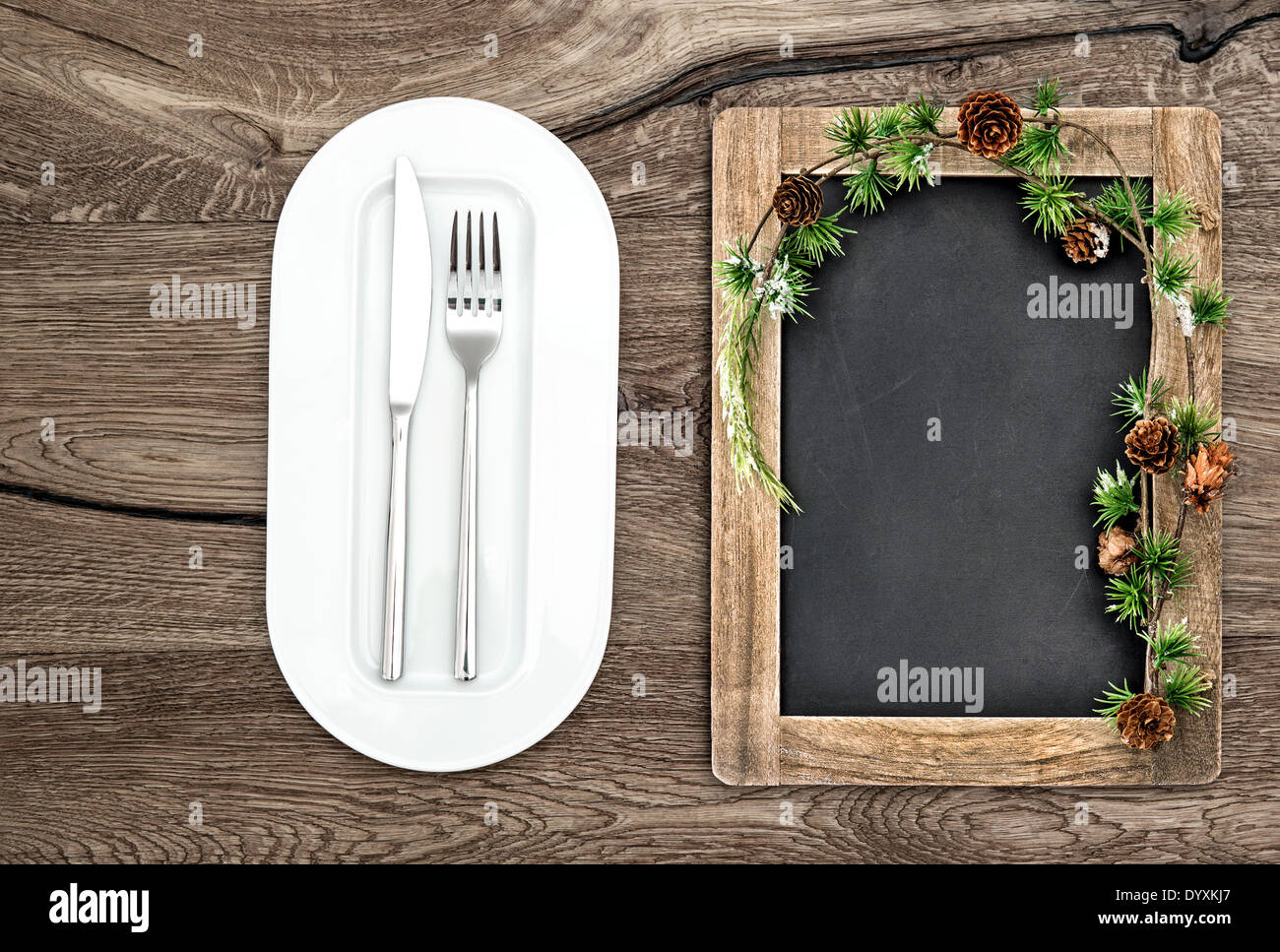 Tafel mit Weihnachtsbaum Äste auf Holztisch. Weihnachten, Silvester, Winter Menü Konzept Stockfoto