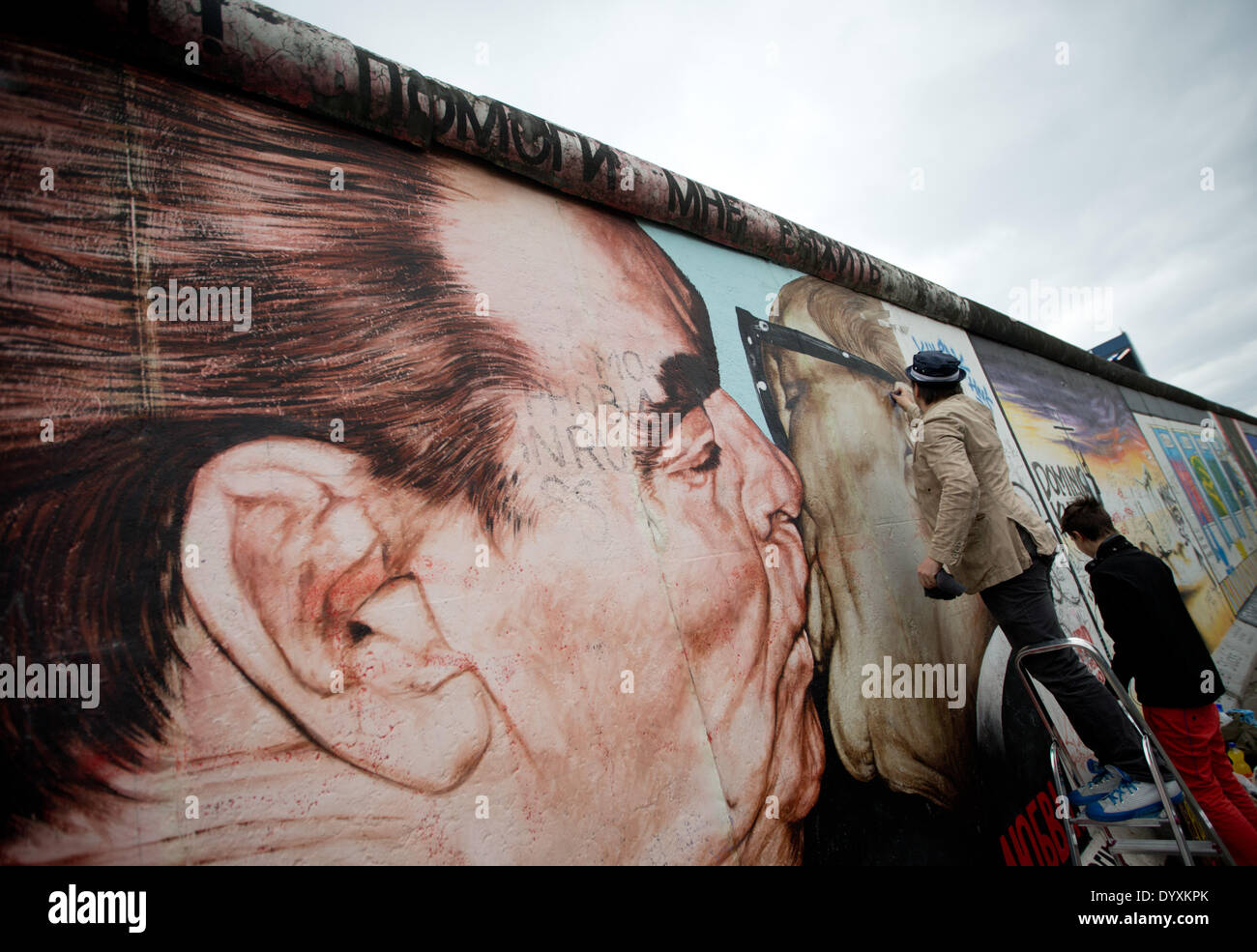 Berlin, Deutschland. 27. April 2014. Künstlers Dimitri Vrubel (L) und Sohn Artjom reinigen das Graffiti-Gemälde von der sozialistischen brüderlichen Kuss an der East Side Gallery in Berlin, Deutschland, 27. April 2014. Menschen und Touristen gereinigt den 1,3 km langen Abschnitt der Berliner Mauer nahe dem Zentrum von Berlin. Foto: KAY NIETFELD/Dpa/Alamy Live News Stockfoto