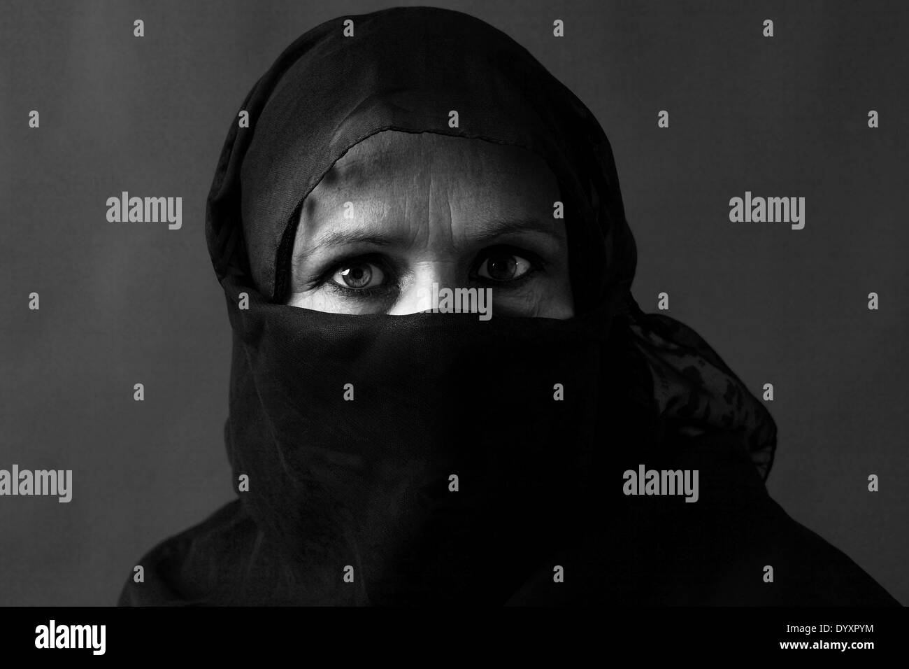 Dramatische schwarz / weiss Portrait von eine verschleierte muslimische Frau mittleren Alters mit starken Blick Stockfoto
