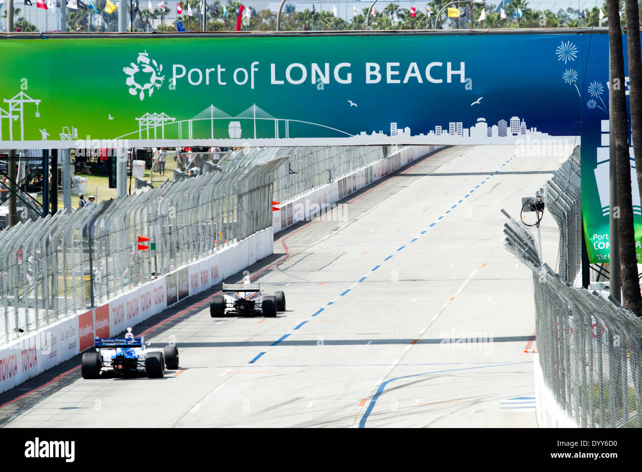 Zwei Indy Autos hinuntersausen Shoreline Drive unter der Hafen von Long Beach Bridge Stockfoto