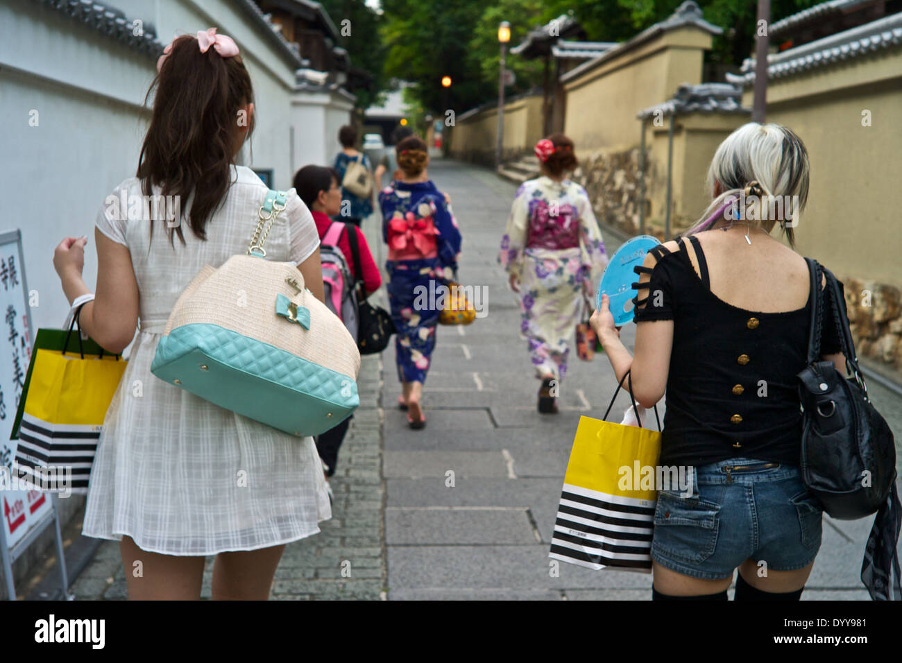 Japanische Teenager gekleidet in sehr modernen Kleidung Kontrast mit anderen traditionellen Kimonos tragen, in der Nähe von Kiyomizu-Tempel. Stockfoto