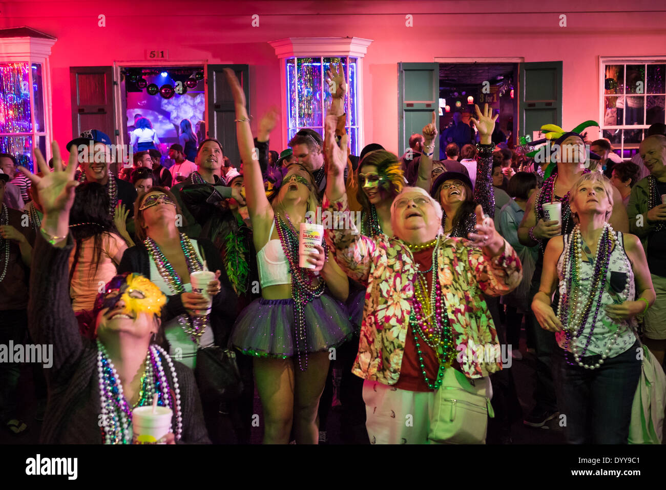 Menschen, nachschlagen und Hände erhebend um Perlen in der Bourbon Street Stockfoto