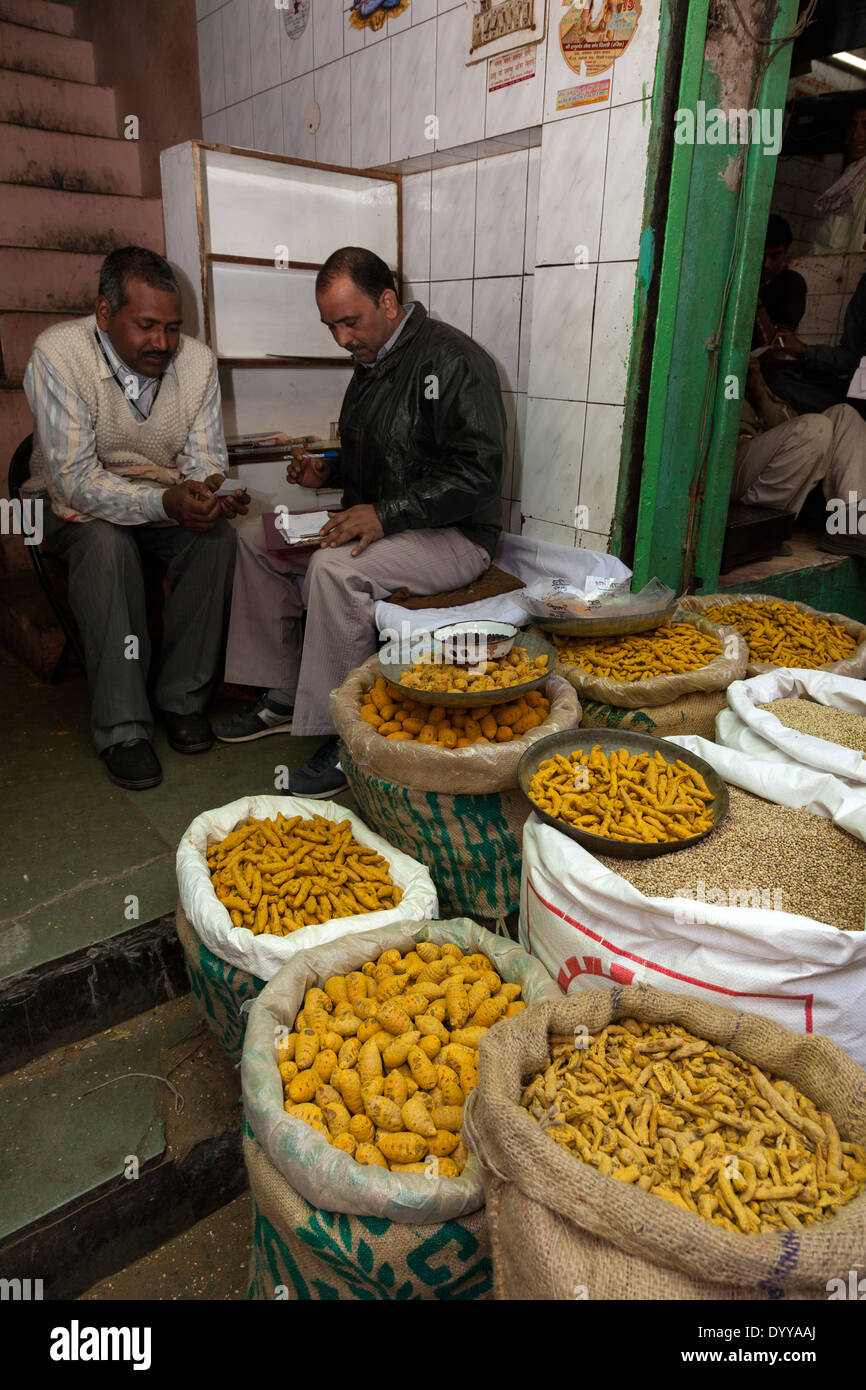 Neu-Delhi, Indien. Ladenbesitzer diskutieren Linsen und andere Lebensmittel zu verkaufen. Stockfoto