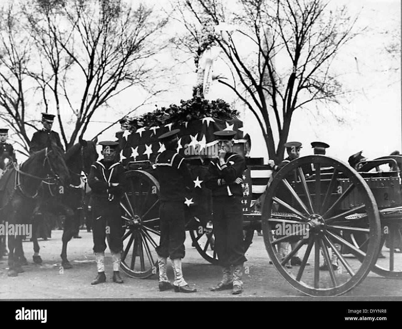Ein Foto des Arlington National Cemetery, Virginia, zeigt eine militärische Beerdigung mit einem Caisson, einem mit Fahnen überzogenen Sarg und Trauernden. Das Bild fängt die feierliche Zeremonie und die historische Bedeutung des Friedhofs ein. Stockfoto Ein Foto des Arlington National Cemetery, Virginia, zeigt eine militärische Beerdigung mit einem Caisson, einem mit Fahnen überzogenen Sarg und Trauernden. Das Bild fängt die feierliche Zeremonie und die historische Bedeutung des Friedhofs ein. Stockfoto